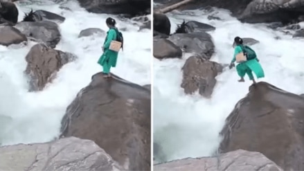 Kamla Devi, a 40-year-old health worker, was seen jumping from one boulder to another as she held her shoes in one hand and her backpack over her shoulders to cross the raging waters in Mandi district. (X/@iNikhilsaini)