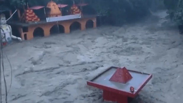 Heavy rainfall in Dehradun, Uttarakhand, caused the Tamsa river to overflow and flood the famous Tapkeshwar Mahadev temple. Water entered the temple cave, submerging the Shivling and also rose in the courtyard up to the statue of Lord Hanuman. (Photo Source: PTI)