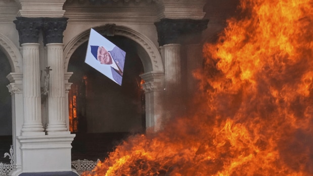 Protesters burn a photograph of Nepal's Prime Minister Khadga Prasad Oli at the Singha Durbar, the seat of Nepal's government's various ministries and offices during a protest against social media ban and corruption in Kathmandu. (Photo Source: Associated Press)