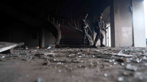 Nepalese army personnel clear civilians inside the burnt parliament building as the protest began to escalate on September 9. (Photo Source: Associated Press)