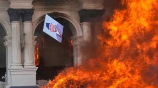 A protester throws a photograph of Nepal Prime Minister Khadga Prasad Oli in the fire at Singha Durbar, the seat of Nepal's government's various ministries and offices (Photo: AP/PTI)