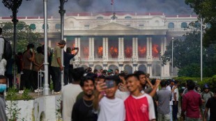 Protesters take selfies and celebrate at the Singha Durbar, the seat of Nepal's government's various ministries and offices (AP Photo)