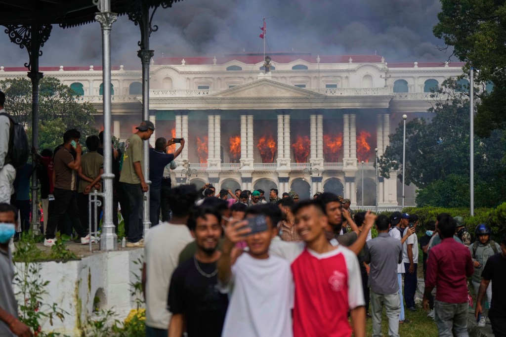 Protesters take selfies and celebrate at the Singha Durbar, the seat of Nepal's government's various ministries and offices (AP Photo) Protesters take selfies and celebrate at the Singha Durbar, the seat of Nepal's government's various ministries and offices (AP Photo)