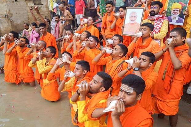 Young men blow ‘shankh’, conch shell, as they perform rituals for PM Modi on his birthday, at Dashashwamedh Ghat, in Varanasi, Uttar Pradesh. (Photo source: PTI)