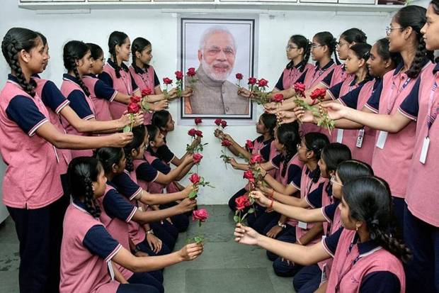 Students of Gyan Ganga Vidyalaya celebrate the birthday of PM Modi by offering roses to the PM's portrait, in Surat on Wednesday. (Photo source: ANI)
