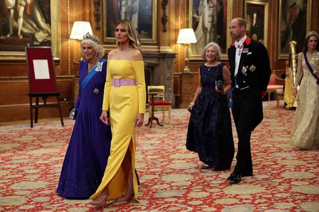 Melania Trump wore an off-the-shoulder gown, and Queen Camilla was seen in White and pearls for the evening. (Photo source: AP)