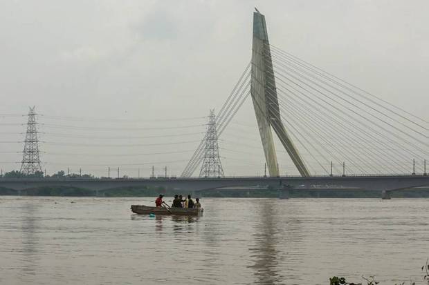 Visitors take a boat ride in the swollen Yamuna River at Wazirabad, in New Delhi. (Photo source: PTI)