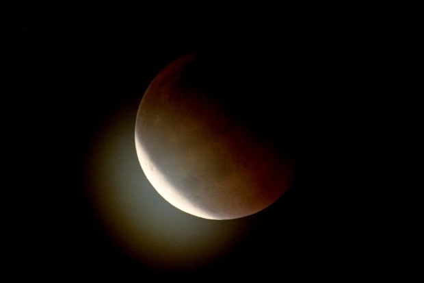 A lunar eclipse occurs when the Earth moves directly between the Sun and the Moon, preventing sunlight from reaching the lunar surface. Instead of disappearing in darkness, the Moon takes on a reddish tint because Earth’s atmosphere bends and scatters light.  (Image: AP)