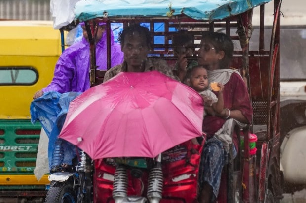 An e-rickshaw driver makes his way through steady rainfall, trying to continue his daily work despite the wet and challenging conditions. (Source: PTI)
