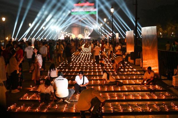 Volunteers light rows of lamps on Kartavya Path near India Gate as part of the Delhi government's Diwali celebrations. (AP)