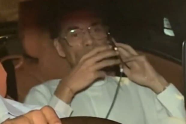 Karan Johar appeared busy on a call as pictures and videos of him attending the memorial appeared on social media platforms. (Image source: X)