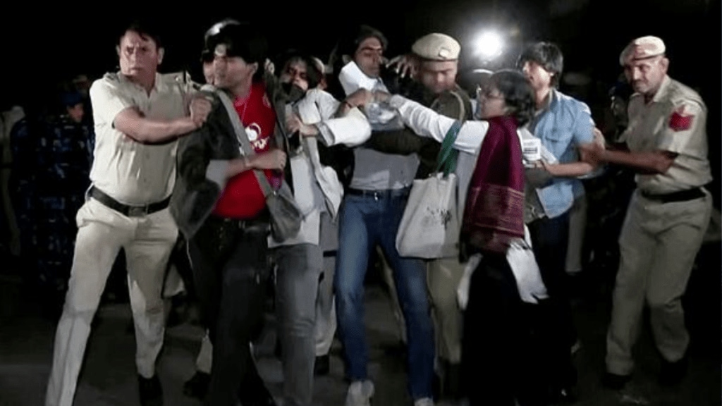 Police personnel detain protesters during the protest against rising air pollution at India Gate, in New Delhi on Sunday