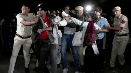 Police personnel detain protesters during the protest against rising air pollution at India Gate, in New Delhi on Sunday