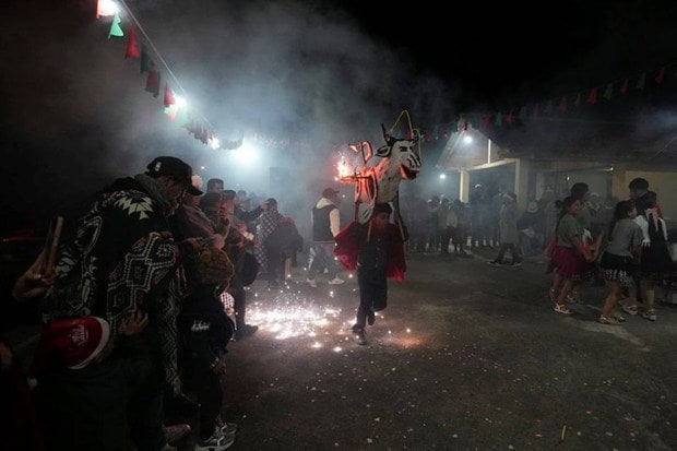 A child is seen running with a traditional vaca loca or crazy crow during the Christmas festivities in Ecuador. (Photo source: AP)