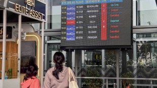 Passengers check updates on the display board amid IndiGo flight disruptions, at Netaji Subhash Chandra Bose International Airport in Kolkata, Saturday, Dec. 6, 2025. (PTI Photo)