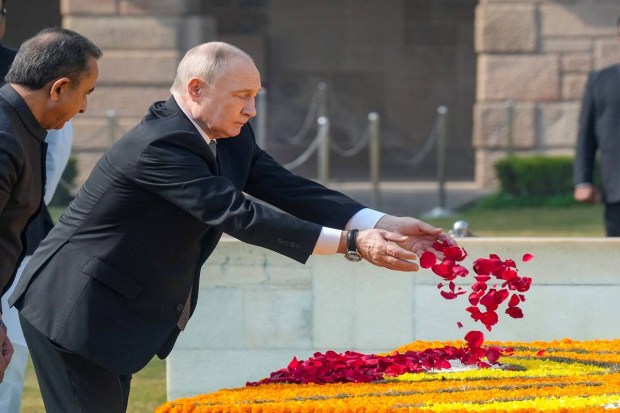Putin pays homage at Rajghat, laying a wreath and signing the visitors' book. (Photo source: PTI)
