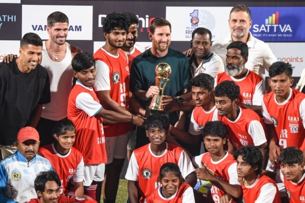 Telangana Chief Minister Revanth Reddy and Argentine football great Lionel Messi present a trophy to a football team during an event held as part of the second leg of the GOAT India Tour 2025 in Hyderabad. Lok Sabha Leader of Opposition Rahul Gandhi, along with Inter Miami players Rodrigo De Paul and Luis Suárez, are also seen. (Image: PTI)