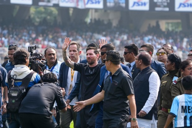 Argentine footballer and 2022 FIFA World Cup–winning captain Lionel Messi greets fans during the GOAT India Tour 2025 event at Vivekananda Yuba Bharati Krirangan, also known as Salt Lake Stadium, in Kolkata. West Bengal Sports Minister Aroop Biswas is also seen. (Image: PTI)