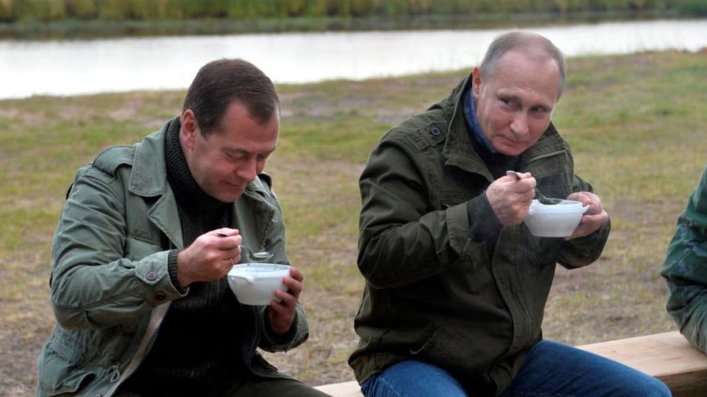 Vladimir Putin enjoying a meal with Dmitri Medvedev after touring on Lake Ilmen. (Image source: Reuters)