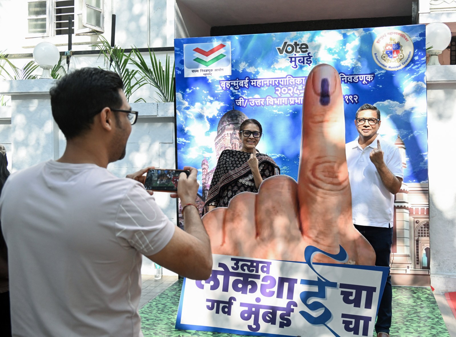 Maharashtra Election Results Vote Counting Begins: A man takes a photograph as voters show their inked fingers at an awareness installation during the Municipal Corporation elections in Mumbai (Photo: ANI)