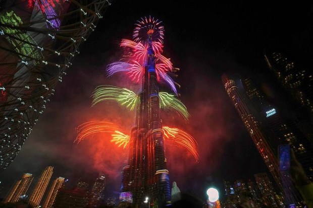 Fireworks warp around the Burj Khalifa, the world’s tallest building, creating a towering light display for New Year’s Eve in Dubai. (Photo source: AP)