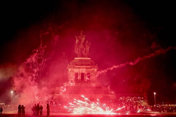 Visitors watching New York fireworks beside the equestrian statue of Kaiser, Wilhelm, at Koblenz, Germany (Photo source: AP)