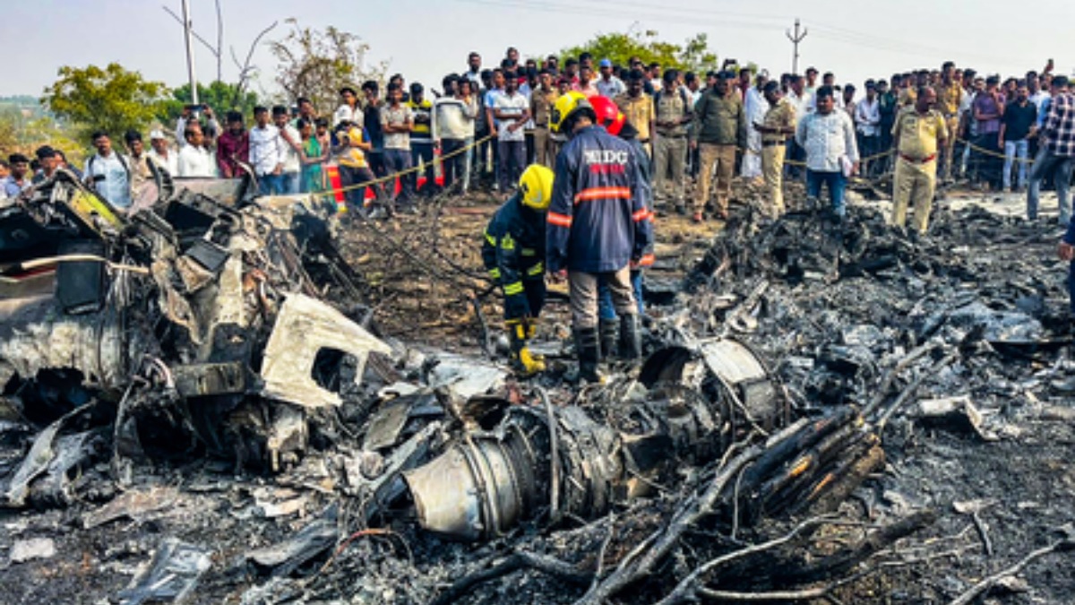 Emergency responders near the wreckage of a Learjet aircraft after a fatal crash close to Baramati airport in Maharashtra.