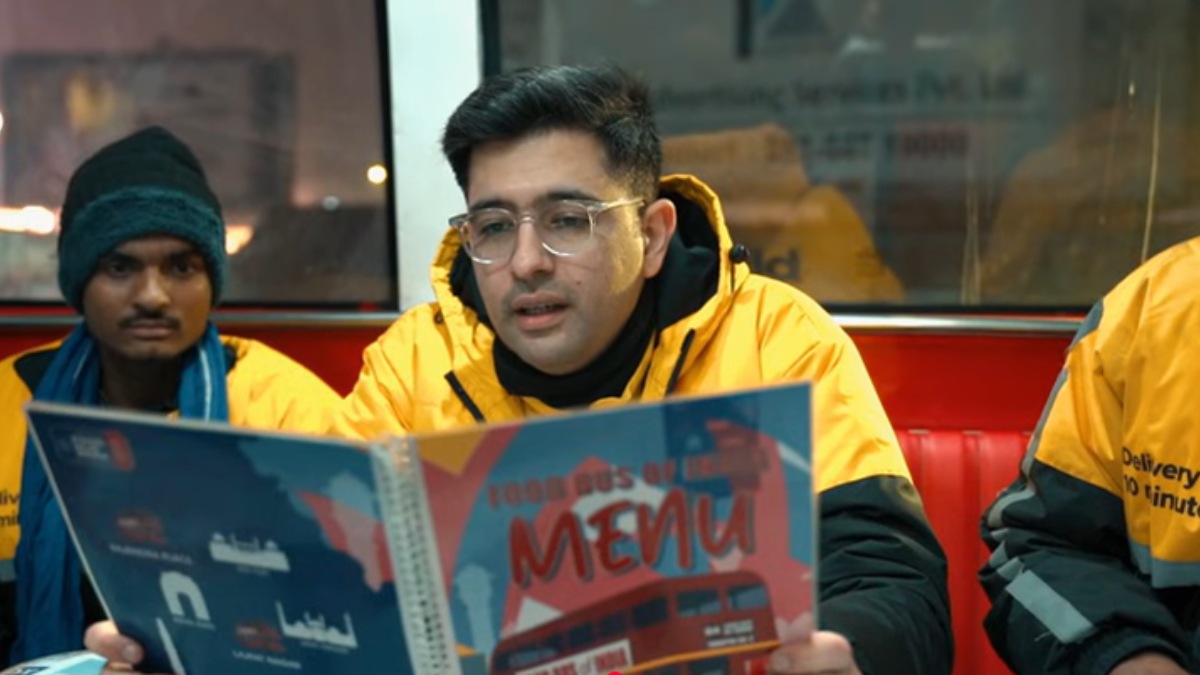 Raghav Chadha wearing a quick-commerce delivery jacket while riding a two-wheeler with a gig worker in Delhi during his night delivery shift.