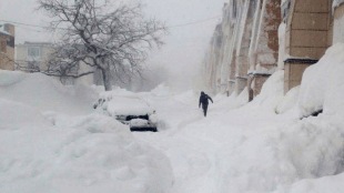 People clearing snow-covered cars and roads amid extreme snowfall in Petropavlovsk-Kamchatsky, Kamchatka Peninsula, Russia.