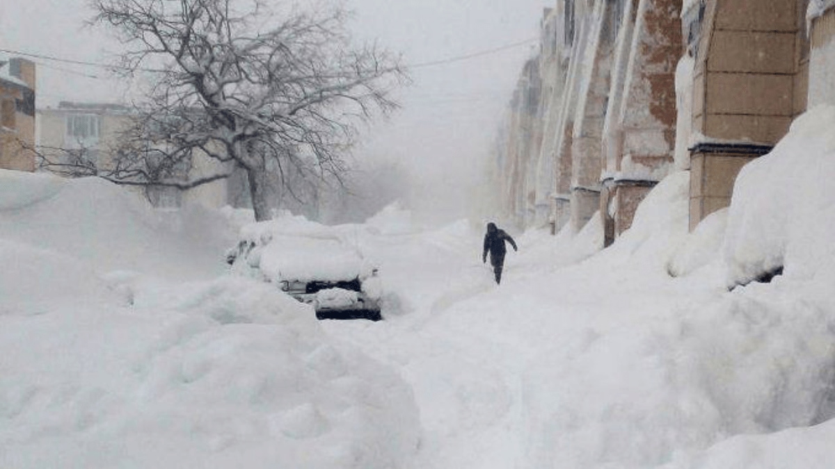 People clearing snow-covered cars and roads amid extreme snowfall in Petropavlovsk-Kamchatsky, Kamchatka Peninsula, Russia.