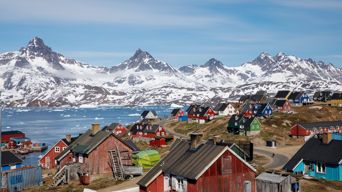 Snow covered mountains rise above the harbour and town of Tasiilaq. Greenland lacks basic infrastructure for its tiny population of 56,000 (Image source: Reuters)