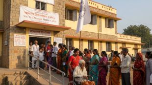 A diverse queue of Indian voters at a sunlit rural Maharashtra polling station; features a senior citizen in a wheelchair using an accessibility ramp and official election banners dated February 7, 2026.