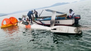 Police personnel inspect the wreckage of a Pawan Hans helicopter that made a controlled emergency landing in the sea near Mayabunder after developing a technical snag shortly after takeoff from Port Blair, in North and Middle Andaman district of the Andaman and Nicobar Islands. (PTI via social media)