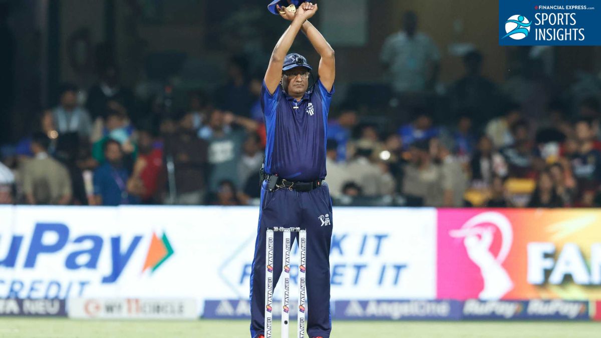 An IPL umpire standing on the field with arms crossed above his head in an 'X' shape to signal the introduction of an Impact Player. An IPL umpire standing on the field with arms crossed above his head in an 'X' shape to signal the introduction of an Impact Player.
