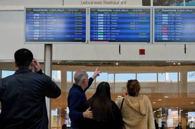 Airlines cancelled flights because of the conflict. People at the Beirut airport are looking at the departure boards. (Photo source: AP)