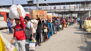 People, many of whom are employed in the textile industry, wait to board a train at Udhna Railway station in Surat, Gujarat. Express Photo