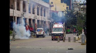 An ambulance passes as smoke billows during a clash after thousands demanding permanent peace were stopped from marching towards the Chief Minister’s residence in Imphal.