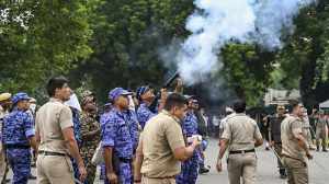 A security officer fires tear gas shells to disperse protesters on Monday (Photo: PTI)
